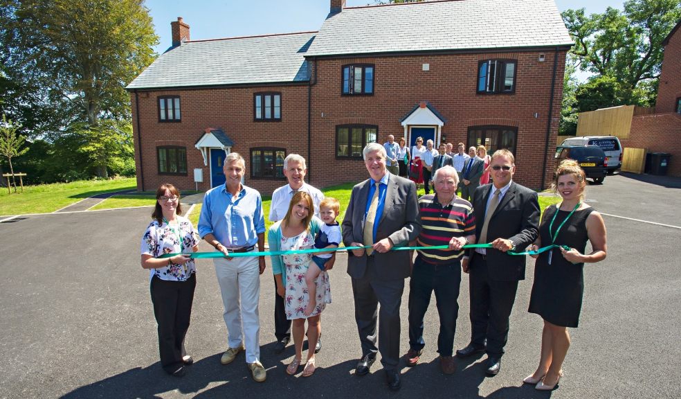 Resident Gemma Gill and son Oscar cut the ribbon at the opening of Nine Barrow view in Steppes (from left): Lisa Sparshott, Raglan Development Officer; Richard Drax MP; Richard Stevenson, Raglan Business Development Director; residents: Gemma and Oscar Gill; Peter Hammond, Raglan Board Member; Cllr Peter White-Langton, Matravers Parish Council; Andy Durant, Contracts Manager, CG Fry and Son; Rebekah Terrell, Raglan Regional Housing Manager.