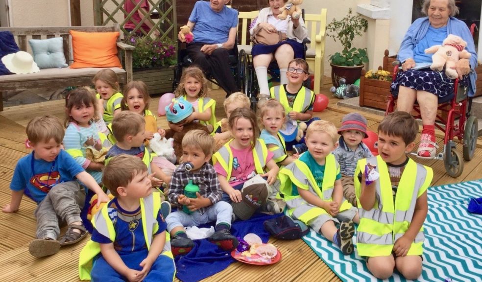 The Seaton’ residents John Dennis, Gail Richardson, and Pam Pearson celebrate ‘International Teddy Bear Picnic Day’ with children from Pink Hippo Nursery and in the care home’s sunny courtyard.