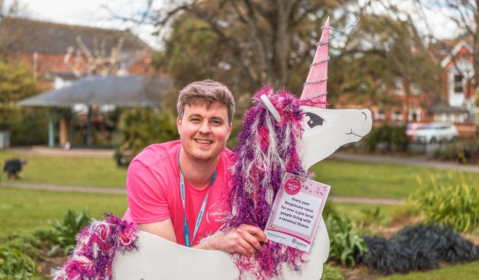 A man in a pink Twilight t-shirt with a cardboard unicorn