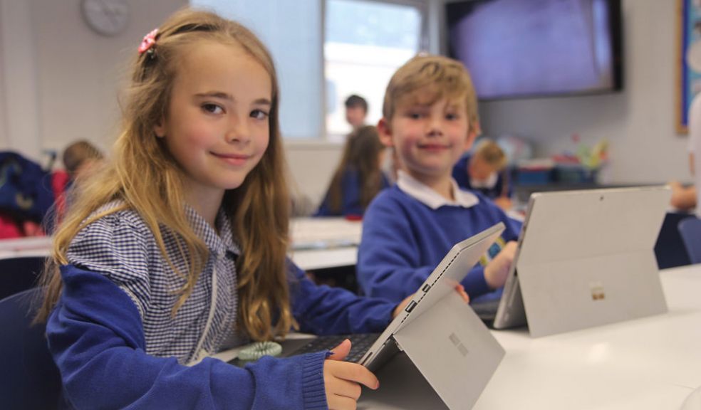 Two Westclyst Community Primary School pupils with their laptops in class