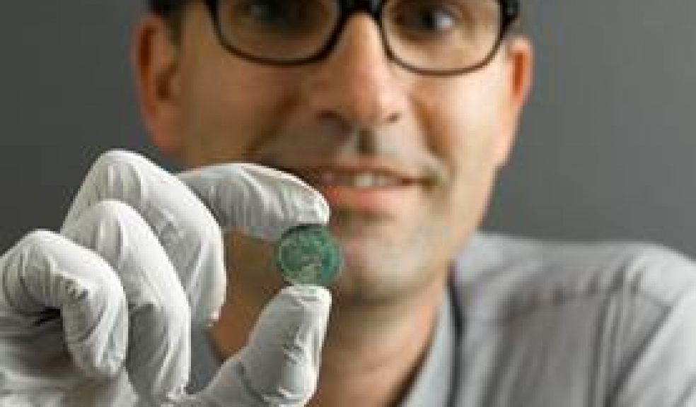 Curator Tom Cadbury with a coin from the Seaton Down hoard.