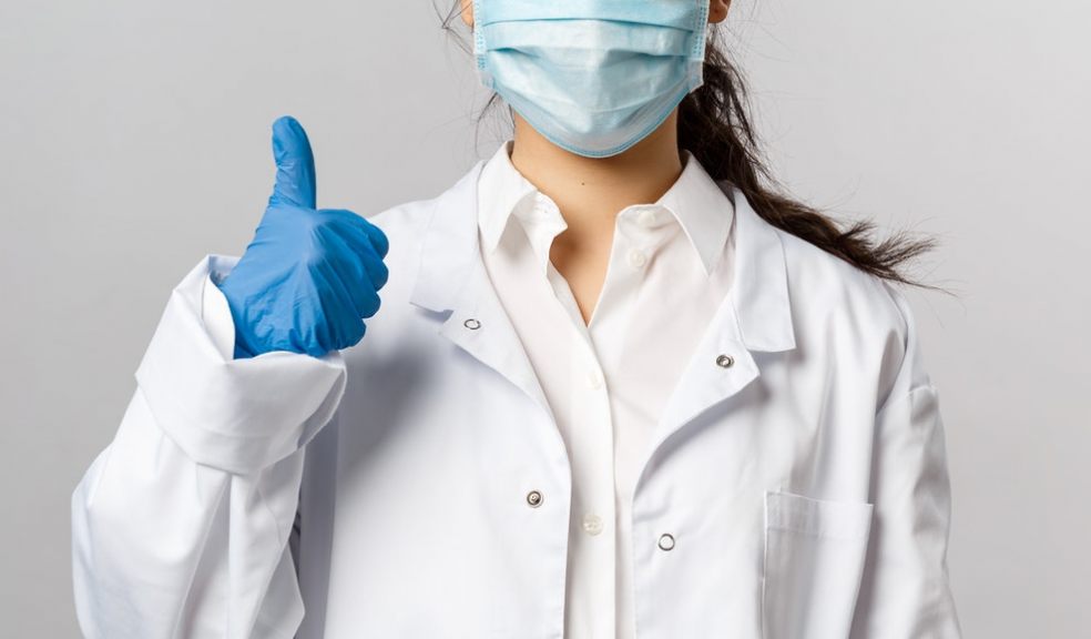 Nurse with mask on gives thumbs up