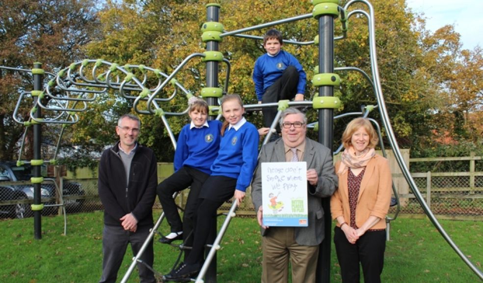 Teacher Ed Thomas and four pupils from Littleham Primary School with one of the new signs on a gateway into the play area beside Littleham Village Hall. To the right of the photo are Helen Wharam and Councillor Peter Sullivan.