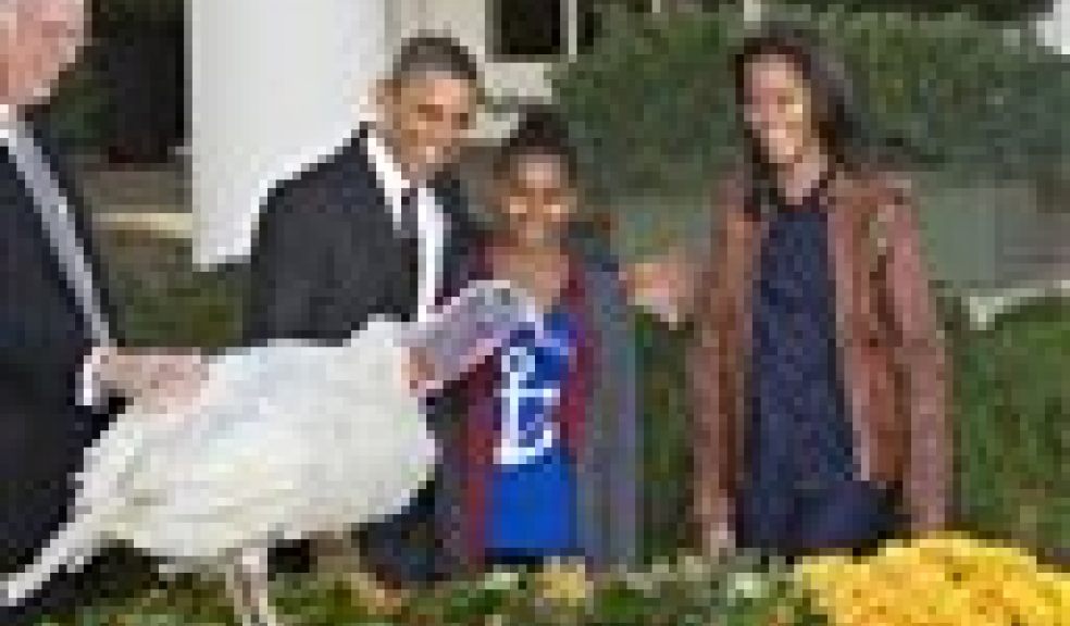 President Barack Obama, with daughters Sasha, center, and Malia, right, carries on the Thanksgiving tradition of saving a turkey from the dinner table with a "presidential pardon," at the White House in Washington, Wednesday, Nov. 21, 2012. After the ceremony, "Cobbler" will head to George Washington's historic home in Virginia to be part of the "Christmas at Mount Vernon" exhibition. National Turkey Federation Chairman Steve Willardsen is at left. (AP Photo/J. Scott Applewhite)