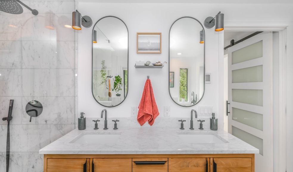 White sink with mirror and silver bathroom accessories.