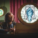 Artist, Patricia Dixon, featuring two of the stained-glass roundels. CREDIT Steve Haywood.