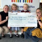 Teachers and children holding a cheque for £2000