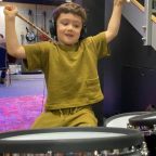 Little boy playing the drums in music studio