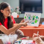 School girl pointing at picture drawn