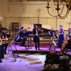 Orchestra playing separate instruments at concert