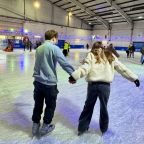 two teenagers ice skating on ice rink