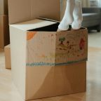 Moving boxes with child's scribble with feet hanging out