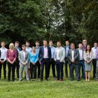 group of men and women from Timewade standing on green grass 