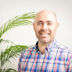 Man in office environment with plant in backgroud