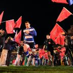 Rugby players running out onto rugby pitch