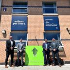 Four Wilson partners stood outside building