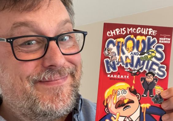 Chris McGuire holding his book
