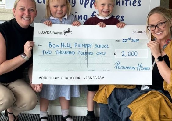 Teachers and children holding a cheque for £2000
