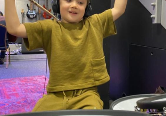 Little boy playing the drums in music studio