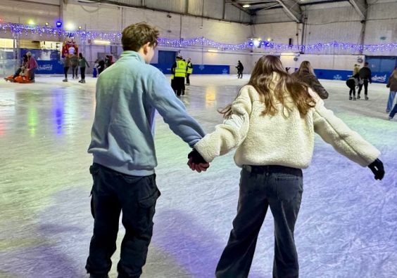 two teenagers ice skating on ice rink