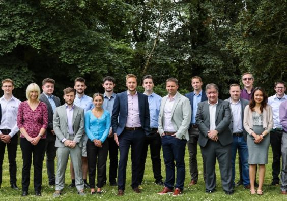group of men and women from Timewade standing on green grass 