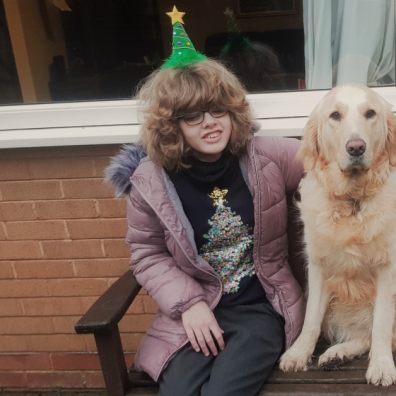 Chloe and Sapphire sit together outside on a wooden bench.