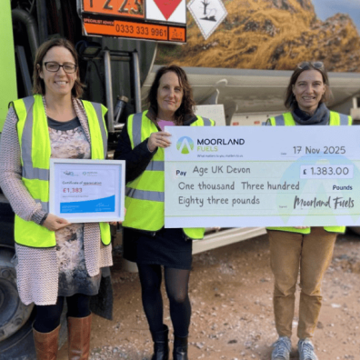 3 women holding up big cheque for Age UK Devon
