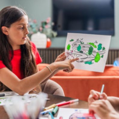 School girl pointing at picture drawn