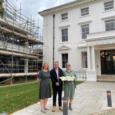 Three people standing outside Winslade House and Winslade Manor