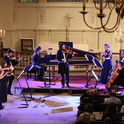 Orchestra playing separate instruments at concert