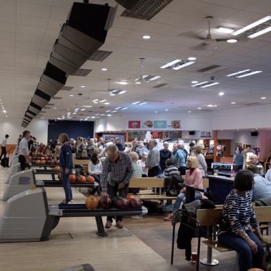 Lots of people bowling in a bowling alley