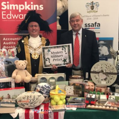 Lord Mayor of Exeter, Councillor Rob Hannaford, and John Coombs, partner at Simpkins Edwards, with auction and raffle items for The Really Big Quiz.