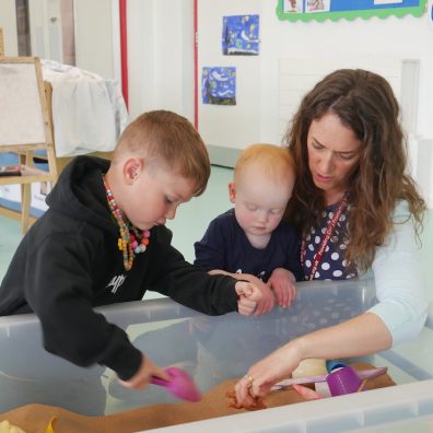Westbank's Kidzone Manager Lucy Elliott with two of the preschoolers in her care