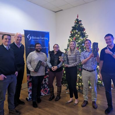 staff who raised money for charity standing in front of a christmas tree
