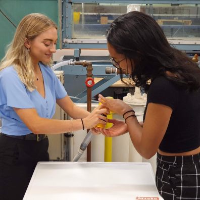 iGEM team members Rachael Quintin-Baxendale (left) and Lydia Pike fitting the filter to a washing machine waste pipe 